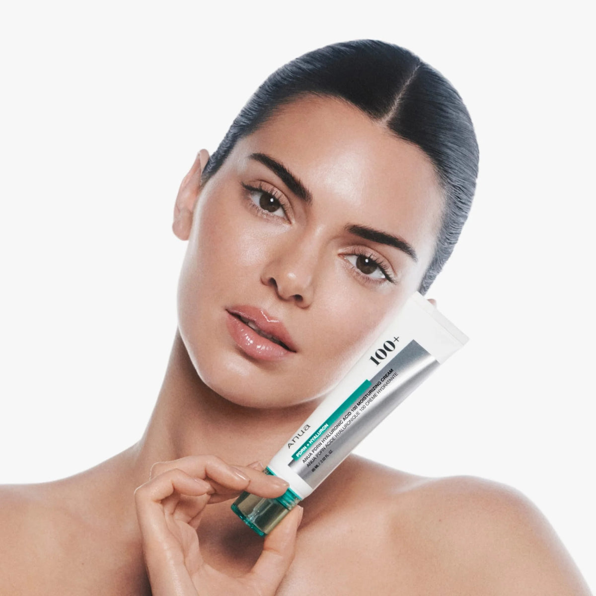 Modelo sosteniendo la crema Anua PDRN junto al rostro
