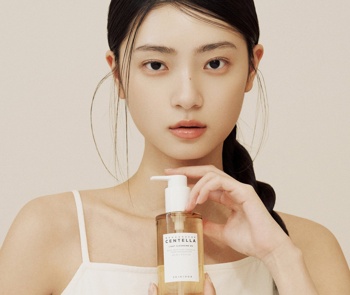 Modelo con el aceite limpiador Centella de SKIN1004