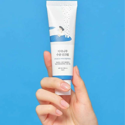 Mano sosteniendo el protector solar Round Lab Birch Juice SPF 50+ PA++++