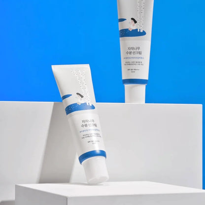 Protector solar Round Lab Birch Juice Moisturizing Sunscreen sobre fondo azul
